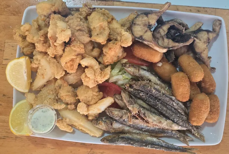Fuente de pescaíto frito con croquetas en un bar de Alcosa